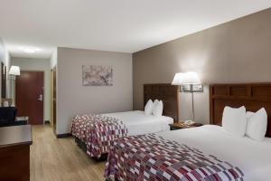 una camera d'albergo con due letti e una televisione di Red Roof Inn & Suites Bloomsburg - Mifflinville a Mifflinville