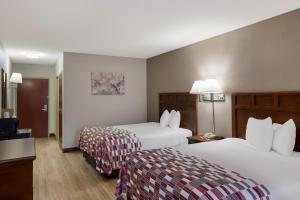 a hotel room with two beds and a television at Red Roof Inn & Suites Bloomsburg - Mifflinville in Mifflinville