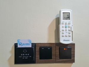 a remote control and a cell phone on a holder at Global Residency in Kota Kinabalu