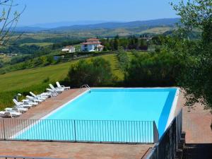 uma grande piscina com espreguiçadeiras e uma casa em Belvilla by OYO Nando em Asciano