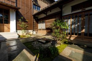 a building with a small garden in front of it at Machi no Odoriba in Kanazawa