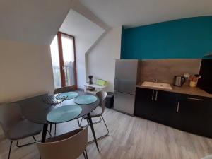 eine Küche mit Tisch und Stühlen in einem Zimmer in der Unterkunft Appartement 2 chambres avec Wi-Fi, proche centre-ville et thermes de La Roche-Posay - FR-1-541-10 in La Roche-Posay