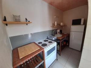 een kleine keuken met een fornuis en een koelkast bij Maison La Puye, 3 pièces, 4 personnes - FR-1-541-63 in La Puye