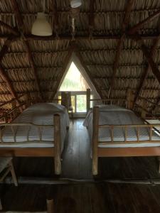 duas camas num quarto com telhado em Cabo tortugas - casa em Monterrico
