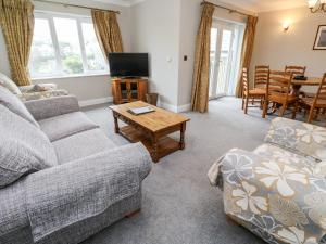 a living room with a couch and a table at 9 Porth Veor Villas in Saint Columb Minor