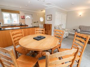 a kitchen and living room with a wooden table and chairs at 9 Porth Veor Villas in Saint Columb Minor