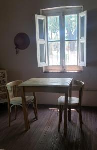 a table and chairs in a room with a window at El Trébol Casa de Campo in Naicó