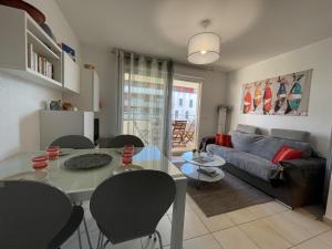 a living room with a table and chairs and a couch at Appartement 2P avec piscine, proche plage et commerces, parking inclus - Sète - FR-1-338-5 in Sète