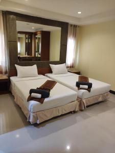 una camera con due letti con lenzuola bianche di Baan Thara Guesthouse ad Aonang Beach