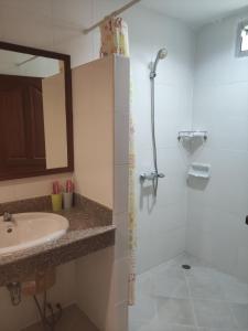ein Bad mit einem Waschbecken und einer Dusche in der Unterkunft Baan Thara Guesthouse in Ao Nang Beach