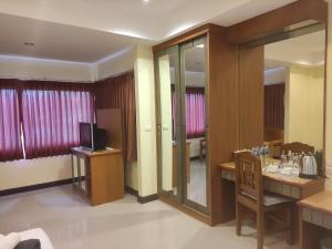 Habitación de hotel con TV, mesa y silla en Baan Thara Guesthouse, en Ao Nang Beach