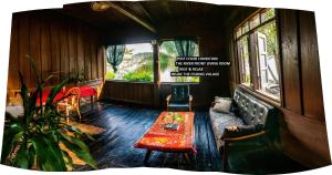 a living room with a couch and a table at Pomelo Restaurant and Guesthouse- Serene Bliss, Life in the Tranquil Southend of Laos in Ban Khon