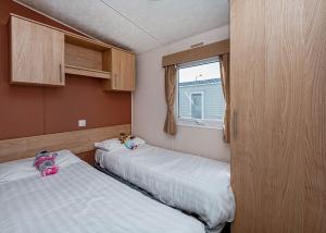 two beds in a small room with a window at Lyons Manor House in Maryport