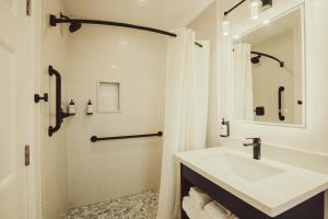 een witte badkamer met een wastafel en een douche bij Blufftop Inn & Suites - Wharf/Restaurant District in Morro Bay