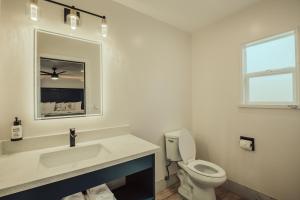 a bathroom with a sink and a toilet and a mirror at Blufftop Inn & Suites - Wharf/Restaurant District in Morro Bay