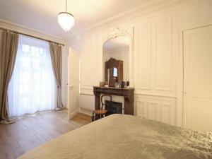 sypialnia z łóżkiem, kominkiem i lustrem w obiekcie Beau T2 en centre-ville du Mont-Dore, au pied des Thermes, pour 4 pers, bien équipé, ascenseur, Wi-Fi - FR-1-608-241 w mieście Mont-Dore