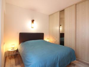 um quarto com uma cama azul e 2 candeeiros em Appartement La Bourboule, 3 pièces, 6 personnes - FR-1-608-239 em La Bourboule