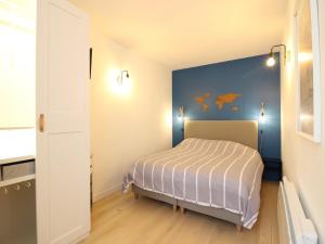 sypialnia z łóżkiem i niebieską ścianą w obiekcie Appartement Splendide T3 à La Bourboule, Proche Parc Fenestre et Thermes - FR-1-608-239 w mieście Bourboule