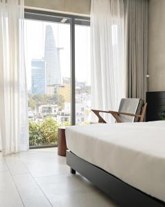 a hotel room with a bed and a large window at Triple E Hotel Metro Ben Thanh in Ho Chi Minh City