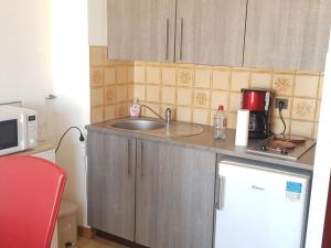 eine kleine Küche mit einer Spüle und einer Mikrowelle in der Unterkunft Studio Valras-Plage, 1 pièce, 2 personnes - FR-1-701-57 in Valras-Plage