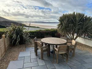 a table and chairs on a patio with a view of the ocean at Southover Beach in Woolacombe