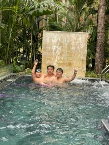 un groupe de trois hommes dans une piscine dans l'établissement Villa & Resort Đại Lải - 3, à Phúc Yên