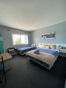 2 camas en una habitación con paredes azules en Dukes Plantation Retro Motel, en Tyndale