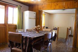 d'une salle à manger avec une table, des chaises et un réfrigérateur. dans l'établissement Posada La Teresita, à La Consulta