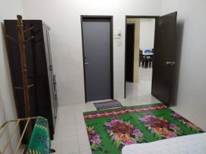 a room with two doors and a rug on the floor at Permai Homestay in Baling