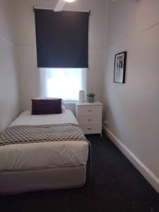 a bedroom with a bed and a window at Heritage Cottage in the heart of Bendigo in Bendigo