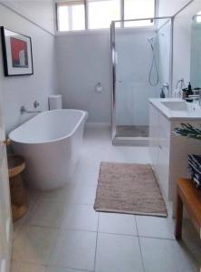 uma casa de banho com uma banheira, um chuveiro e um lavatório. em Heritage Cottage in the heart of Bendigo em Bendigo
