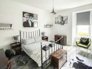 a bedroom with a bed and a chair at Osborne Place in Rothesay