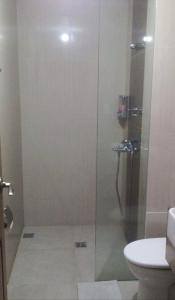 a glass shower in a bathroom with a toilet at Twin lakes Merlot LL3-F in Tagaytay