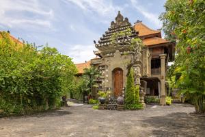 a building with a gate in front of a yard at Giri Bhagawan Villas & Spa in Nusa Dua