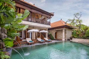 a villa with a swimming pool and a house at Giri Bhagawan Villas & Spa in Nusa Dua
