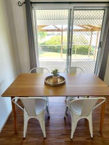 a wooden table with two chairs and a plant on top at Yaringa Cottage, ultimate entertainer! in Encounter Bay