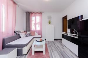 a living room with a couch and a tv at Apartment Mare in Vrsar