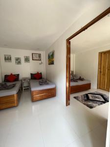 a room with two beds and a mirror at Hutch Lodging House in El Nido