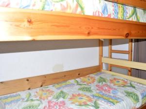 a wooden bunk bed with a flower patterned mattress at Saint Pierre la Mer, Appt 2 pièces, cabine, 6 couchages, près plage, animaux OK - FR-1-229D-249 in Saint Pierre La Mer