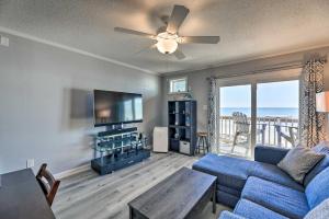 ein Wohnzimmer mit einem blauen Sofa und einem TV in der Unterkunft Beachfront Family Condo with Stunning Views! in North Topsail Beach
