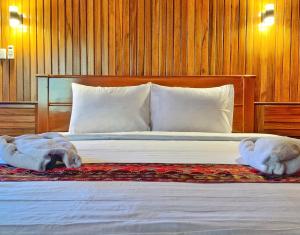 a bed with two towels laying on top of it at Coriana Dive Resort in Waisai