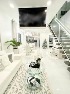 a living room with a white couch and a glass table at Moss Manor in Marsh Harbour