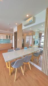 a kitchen with a large white table and chairs at Oceanus Oasis Retreat Muong Thanh Vien Trieu in Nha Trang
