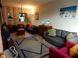 a living room with a couch and a table at Holiday home Sunset in Noordwijkerhout