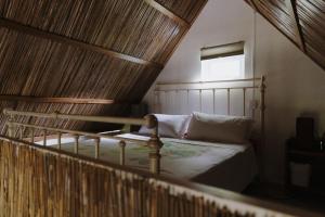 a bedroom with a bed with a wooden ceiling at CASE CREOLE INDEPENDANTE PROCHE MER in La Gaulette
