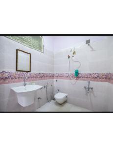 ein Bad mit einem Waschbecken und einem WC in der Unterkunft Hotel The Bay Inn, Konark in Pānchagān