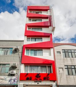un edificio rojo y blanco con edificios en Apple Hotel en Taitung
