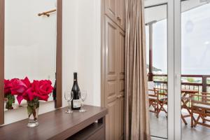 a room with a table with a bottle of wine and roses at Akti Fine Rooms in Skopelos Town