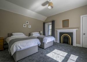 a bedroom with two beds and a fireplace at Gledfield Highland Estate in Culrain