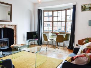 a living room with a glass table and a fireplace at Market Place View in Knaresborough